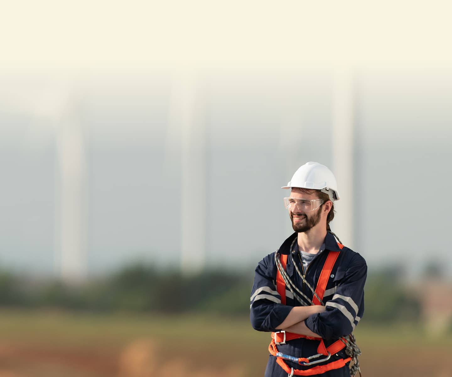Wind turbine technician on the nacelle with blades framing the horizon