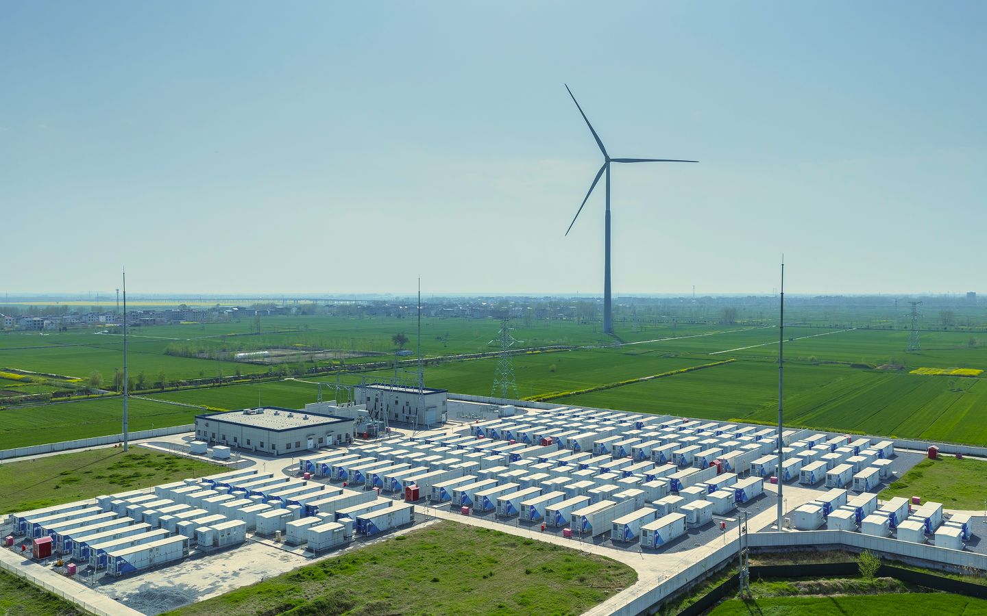 Wind turbines and solar panels at sunset